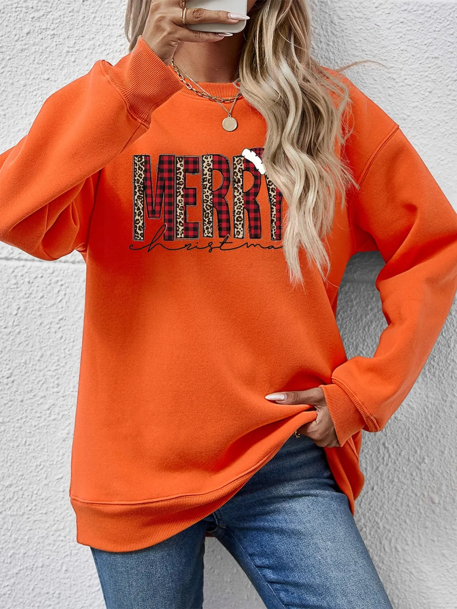 Orange graphic sweatshirt with "Merry Christmas" text in buffalo plaid and leopard print.