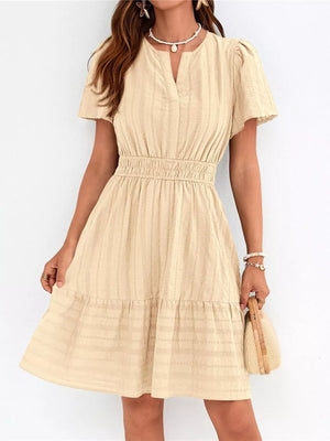 Apricot textured V-neck tiered dress with smocked waist and short sleeves.