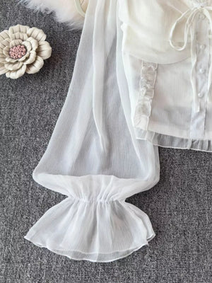 White sheer maternity blouse with ruffled sleeves, decorative bow, and button front.