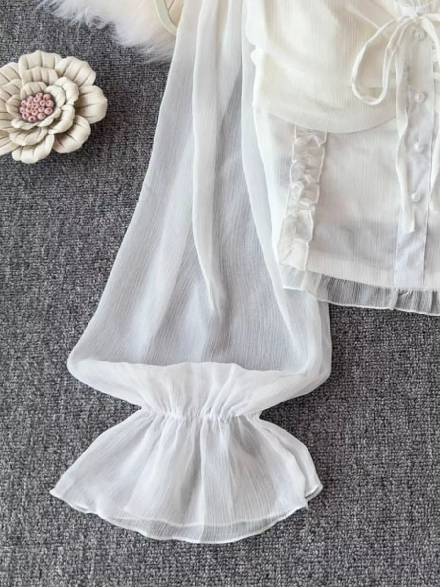 White sheer maternity blouse with ruffled sleeves, decorative bow, and button front.