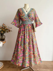Floral lace-trimmed surplice maxi dress in viscose with a vibrant floral print and bell sleeves.
