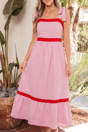 Maxi dress with pink and white stripes, red trim, bow knot straps, and a tiered hem.