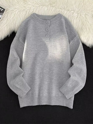 Light gray ribbed knit sweater with button detail at the neckline.