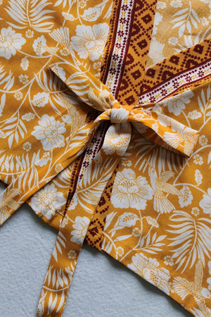 Bohemian floral crop top in tangerine with white print and tie detail.