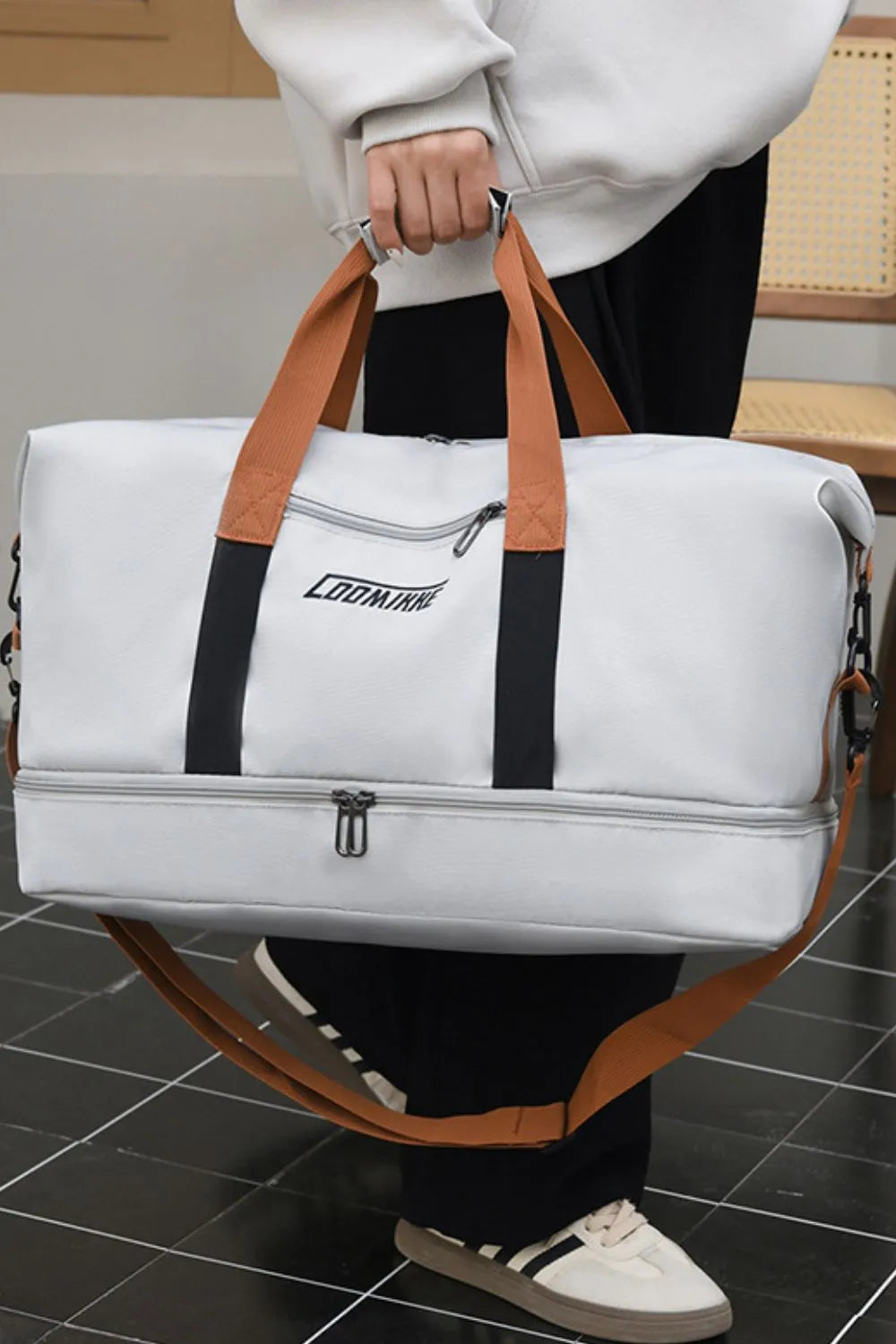 Loomirke Weekend Holdall duffel bag in light gray with dual top handles and a zippered compartment.