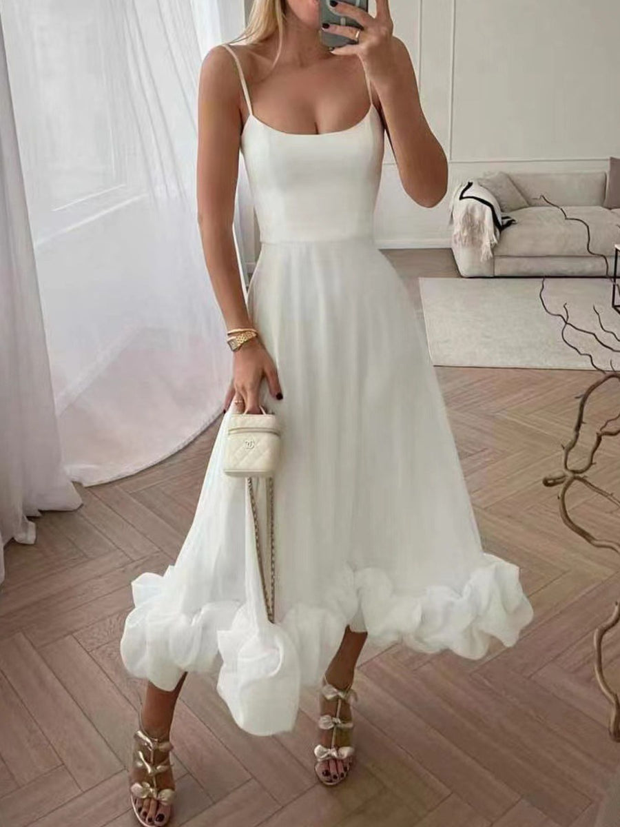 White midi dress with spaghetti straps and a ruffled hem.