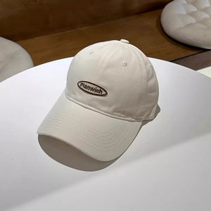 Off-white cotton baseball cap with embroidered oval logo detail.