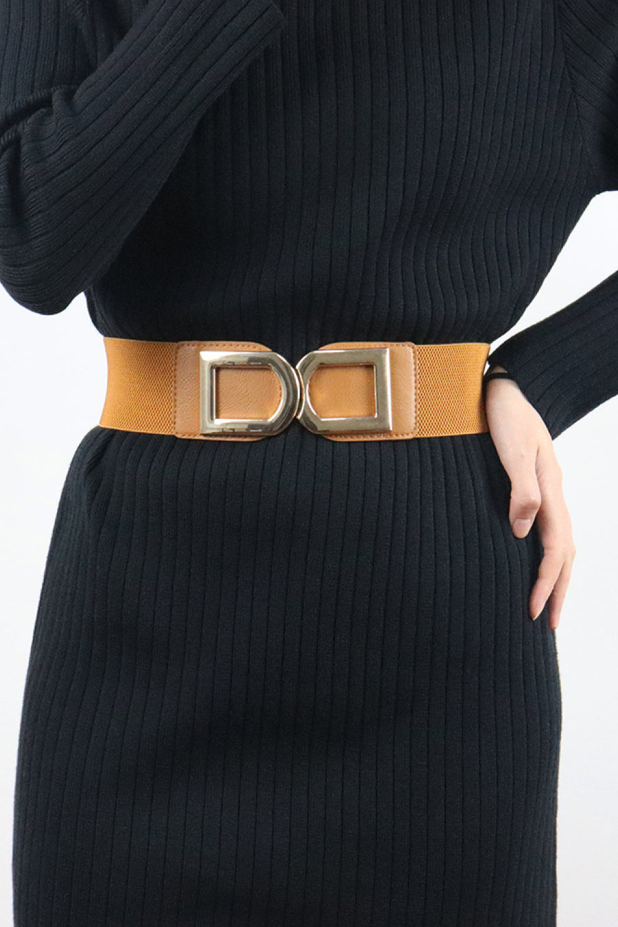 Caramel elastic belt with double square buckle detail worn over black dress
