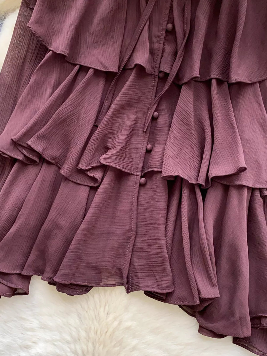 Elegant tiered chiffon blouse in plum with ruffled details and button-down front.