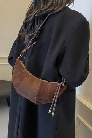 Brown suede crescent shoulder bag with knot detail and gold hardware
