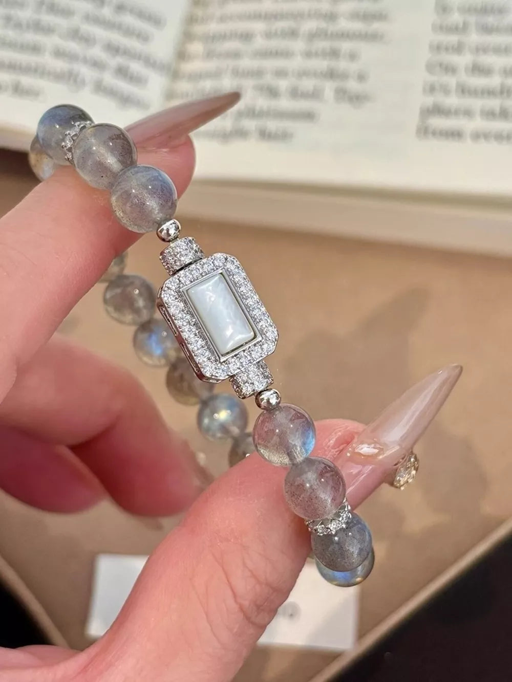Iridescent moonstone beaded bracelet with a rectangular geometric clasp encrusted with tiny diamonds.