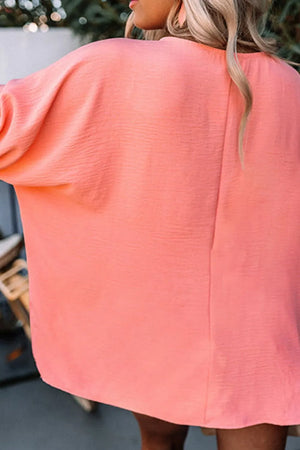 Coral blouson sleeve top with textured fabric and a relaxed fit.