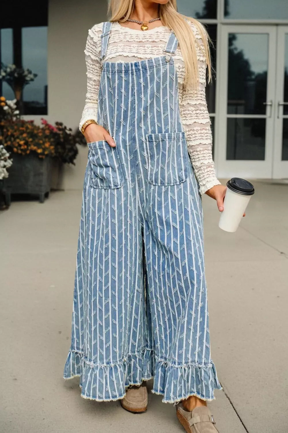 Striped distressed denim overalls with wide legs and ruffled hems.