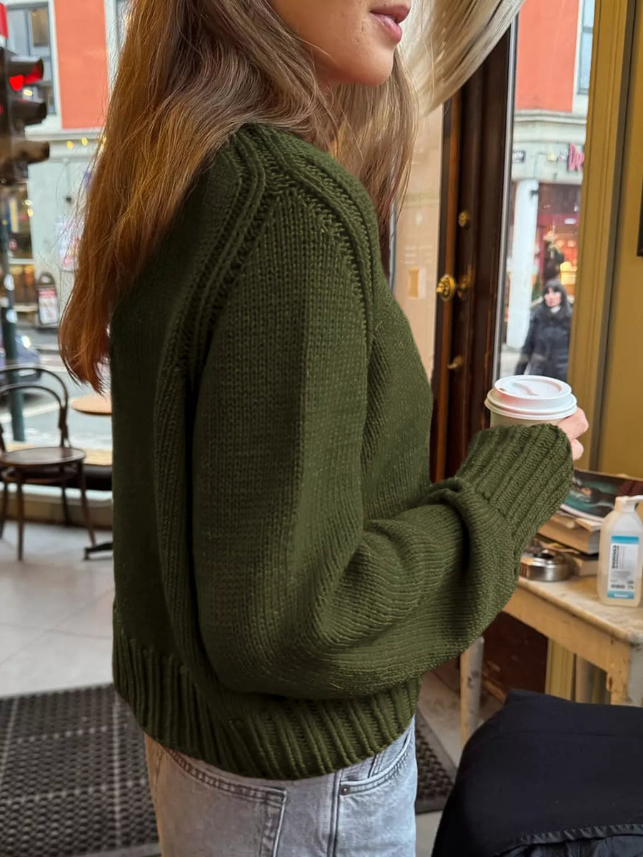 Army green ribbed round-neck knit sweater with detailed shoulder and cuff stitching.