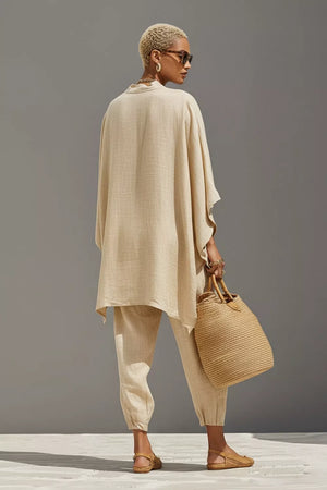 Beige linen two-piece set with relaxed fit tunic and cuffed pants, featuring a pocket detail.