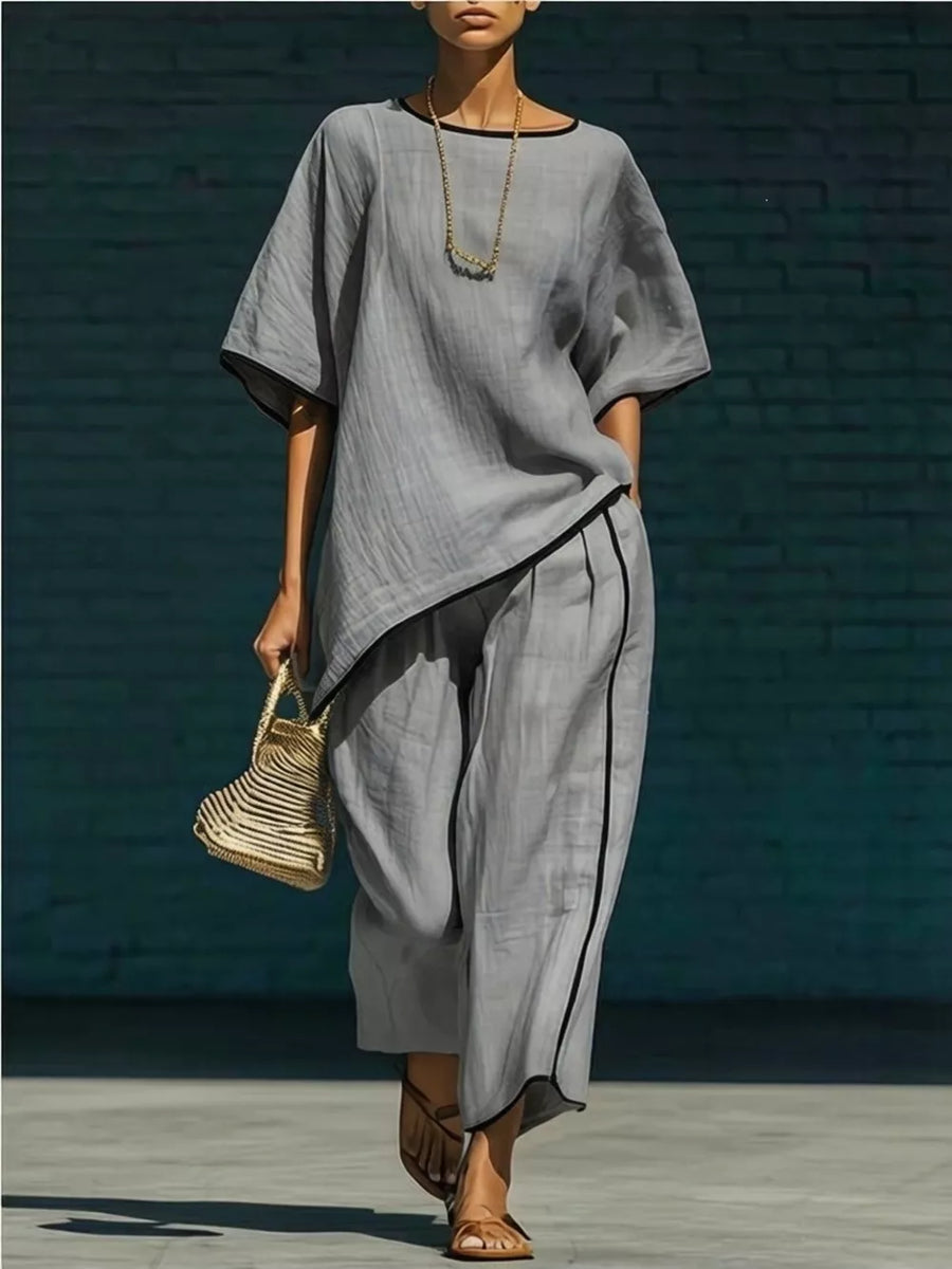 Gray two-piece set with contrast trim, short sleeves, and cropped pants.