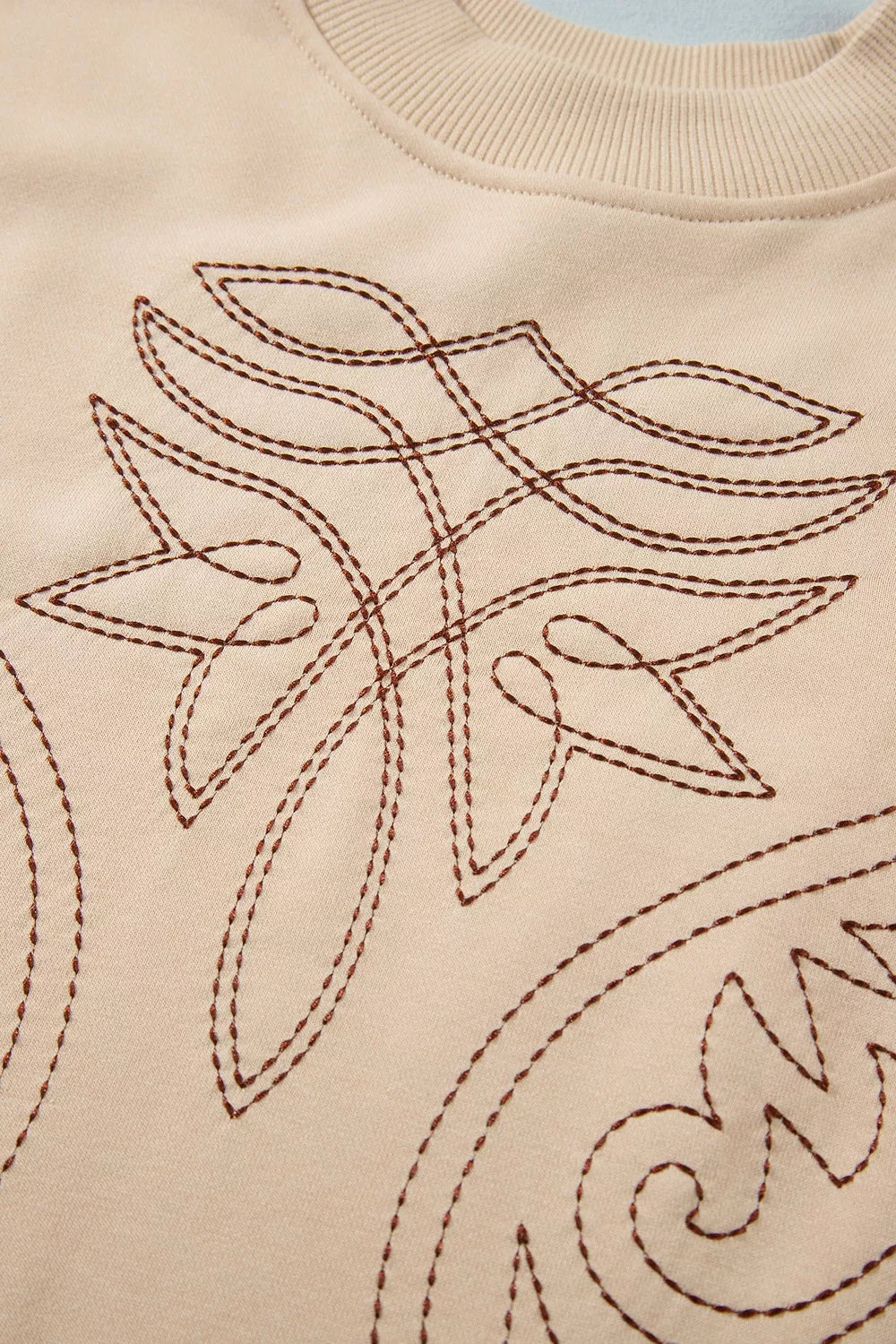 sweatshirt featuring embroidered in Tan with 65% polyester, 35% cotton Care instructions: Machine wash cold texture
