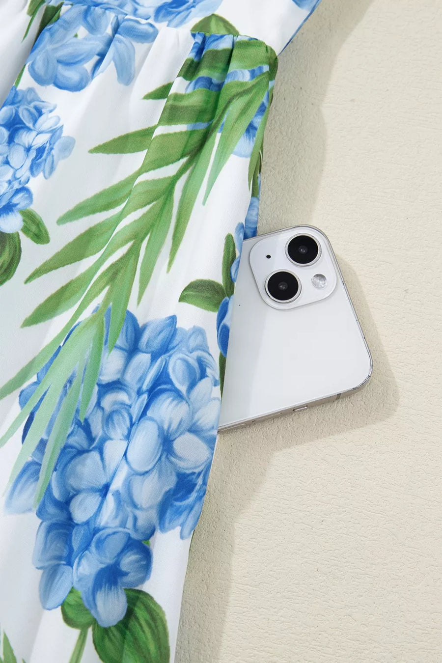 Ruffled mini dress with hydrangea and palm print, featuring a white background and blue floral pattern.