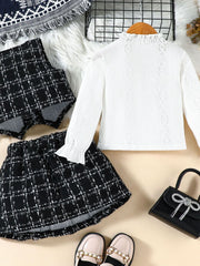 Toddler white lace long sleeve top with ruffled collar and cuffs, paired with a black and white plaid vest and skirt.
