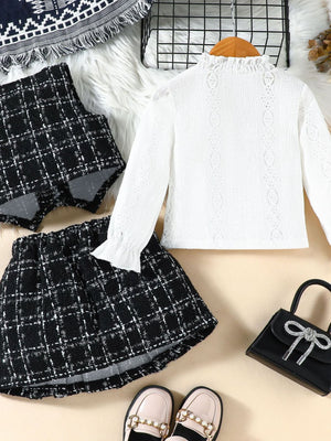 Toddler white lace long sleeve top with ruffled collar and cuffs, paired with a black and white plaid vest and skirt.