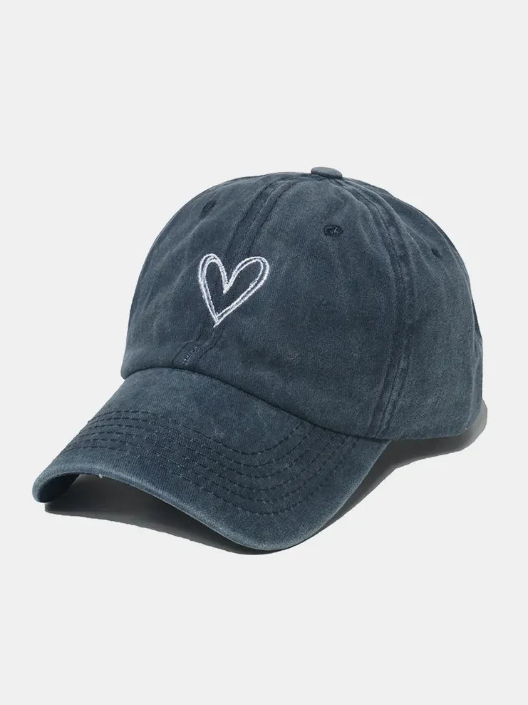 Washed cotton baseball cap in dark blue with white embroidered heart detail.