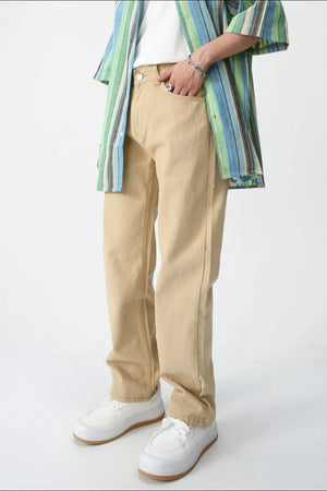 Relaxed fit khaki chino trousers with a straight leg, styled with a striped shirt and white sneakers.