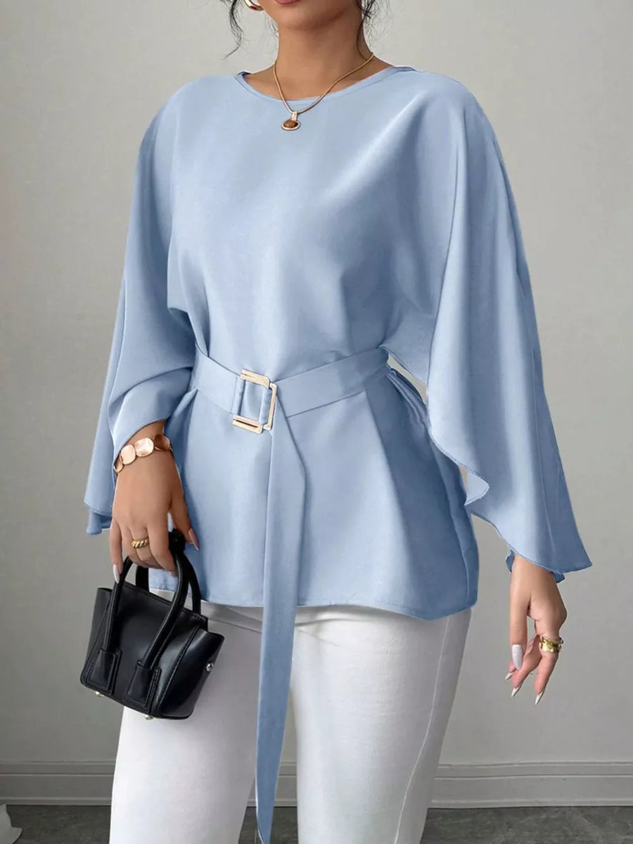 Light blue belted blouse with batwing sleeves and gold buckle detail.