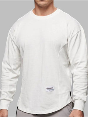 Oversized white long sleeve tee with curved hem and subtle side seams.