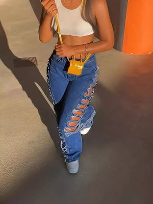 Blue denim jeans with distressed side cutouts and lace-up detail.