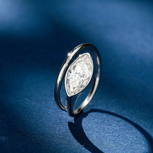 Elegant bypass ring with a large marquise moissanite stone in silver metal.