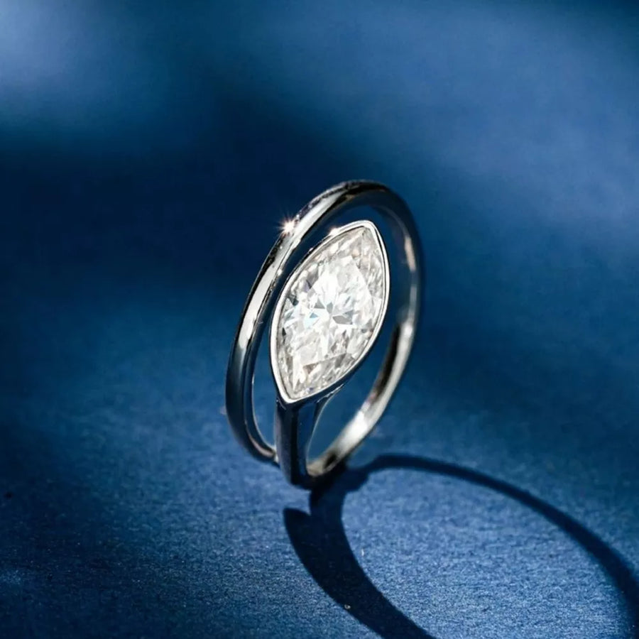 Elegant bypass ring with a large marquise moissanite stone in silver metal.