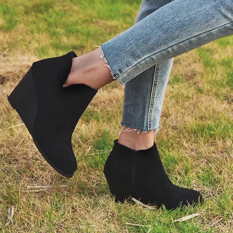 Black wedge ankle boots with side zipper detail.