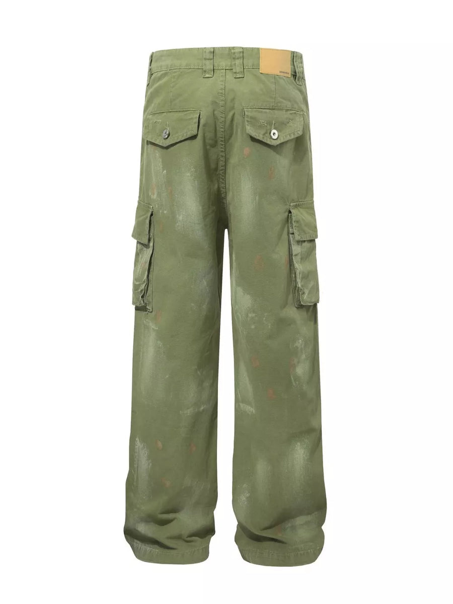 Green distressed cargo pants with multiple pockets and paint-splatter accents.