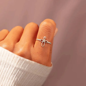 Delicate knotwork silver ring with crystals on a hand wearing a white sweater.