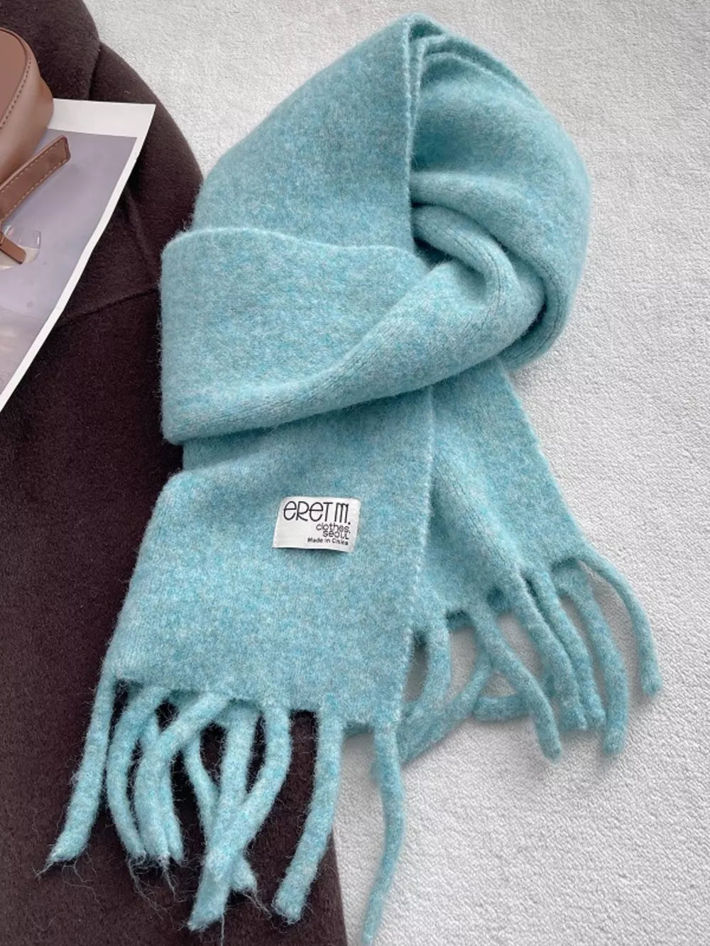 Plush fringe scarf in sky blue with a solid design and soft texture.