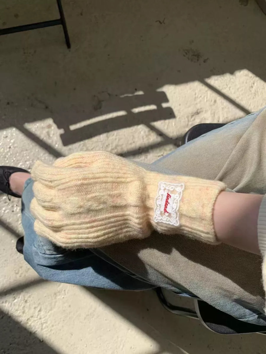 Luxurious yellow cable knit gloves with a decorative tag.