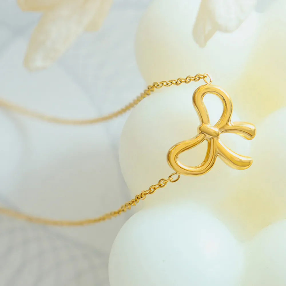 Delicate gold bow pendant necklace with a fine chain.