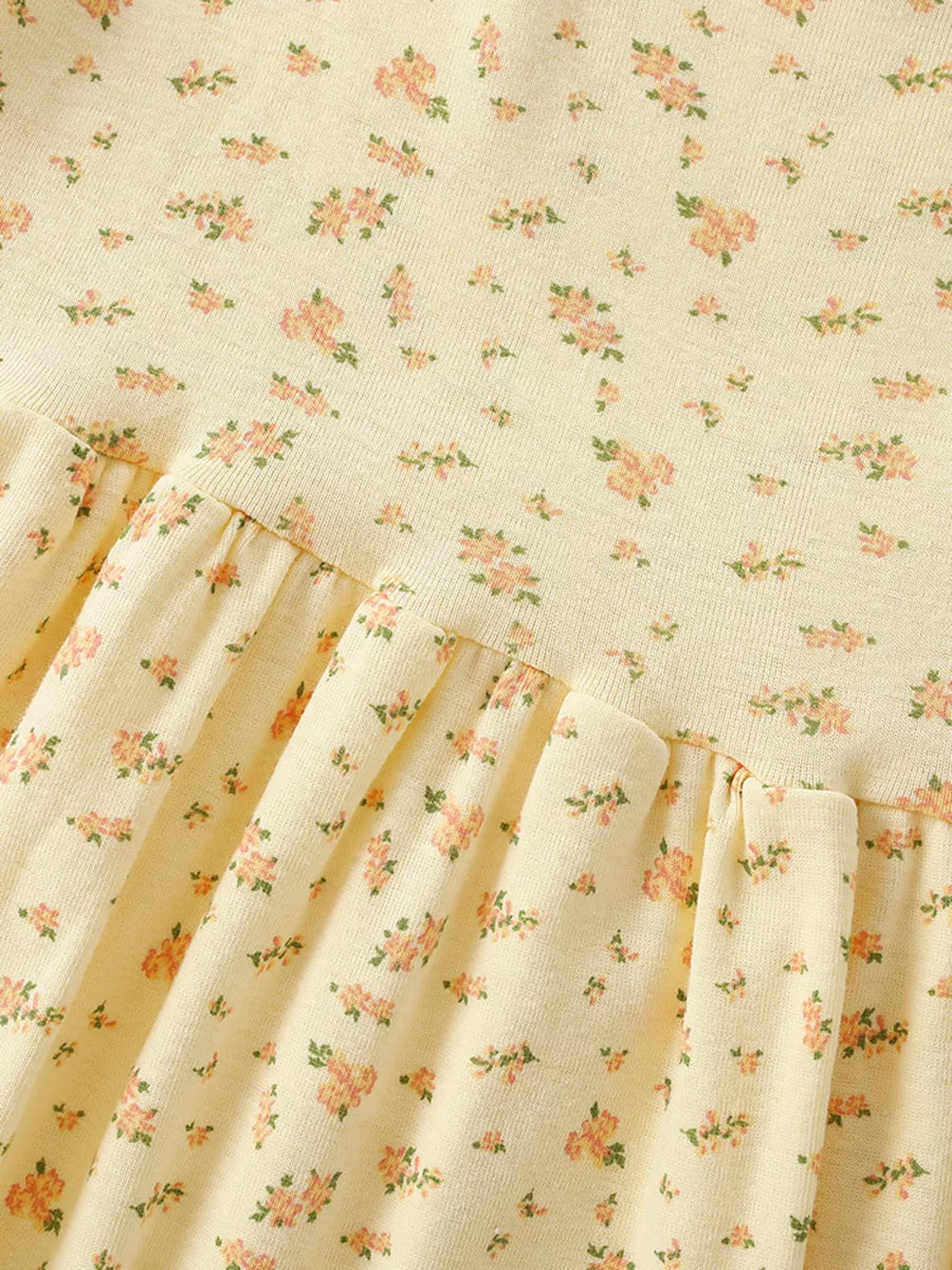 Delicate floral toddler dress in pale yellow with short sleeves and a ruffled hem.