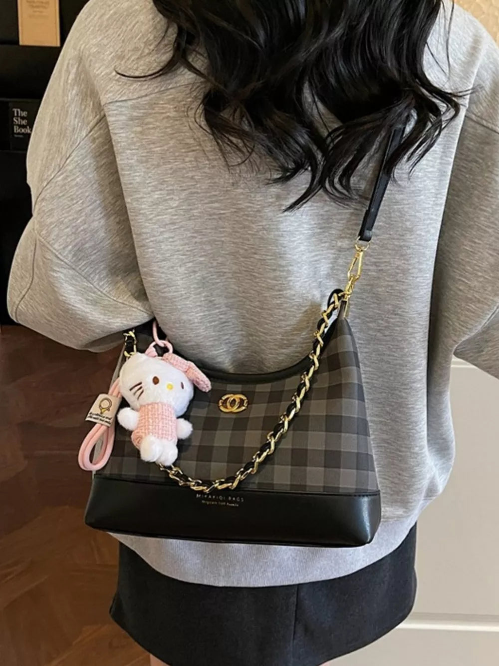 Chic plaid shoulder bag with chain accent and Hello Kitty charm