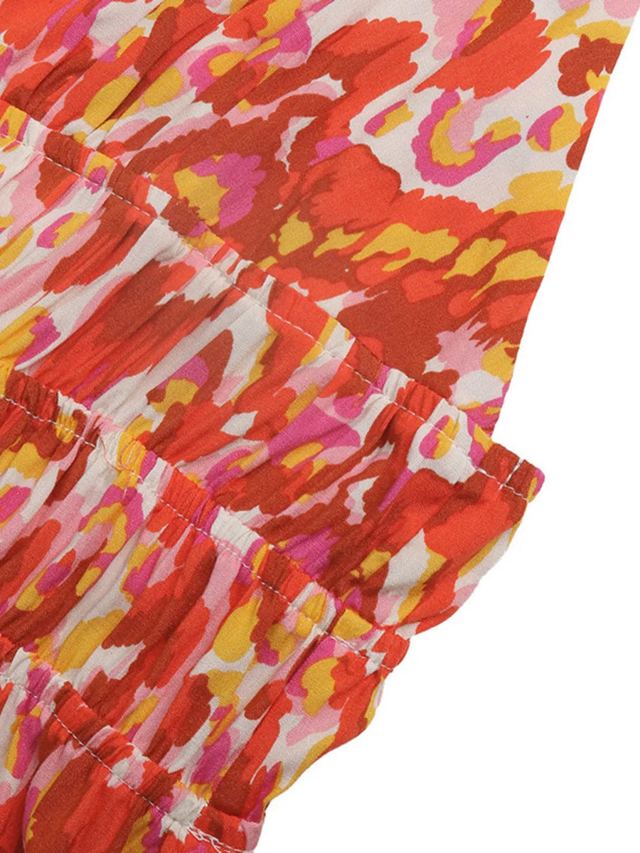 Maxi dress with abstract print in orange, pink, yellow, and white with smocked tiers.