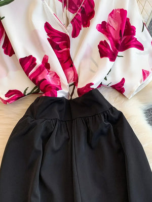 Abstract print wide-leg romper in white with pink floral pattern and black bottom, featuring pockets.