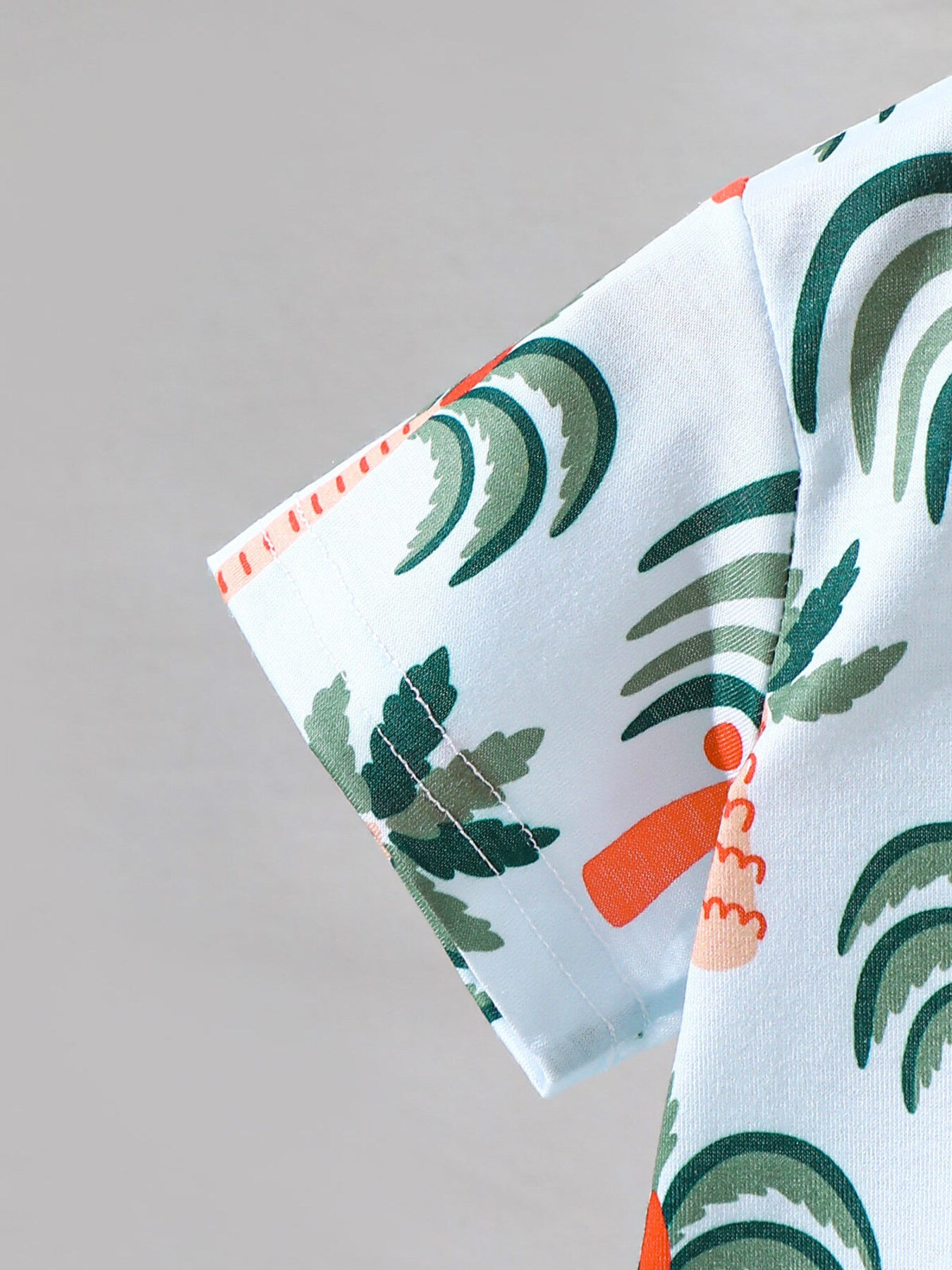 Baby tee with short sleeves and tropical palm tree print in light blue cotton.