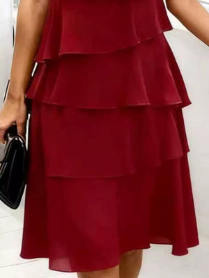 Burgundy tiered dress with ruffled petal sleeves and a flowing skirt.