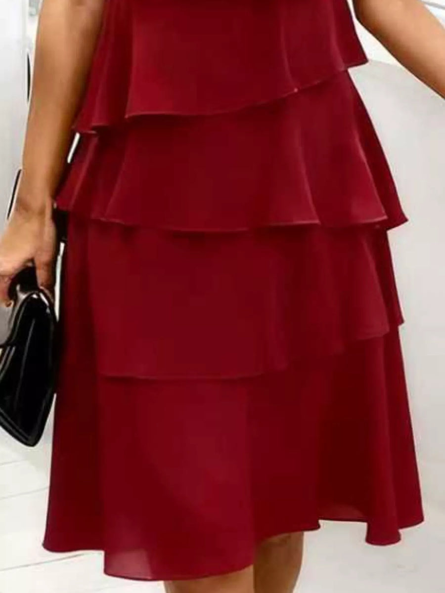 Burgundy tiered dress with ruffled petal sleeves and a flowing skirt.