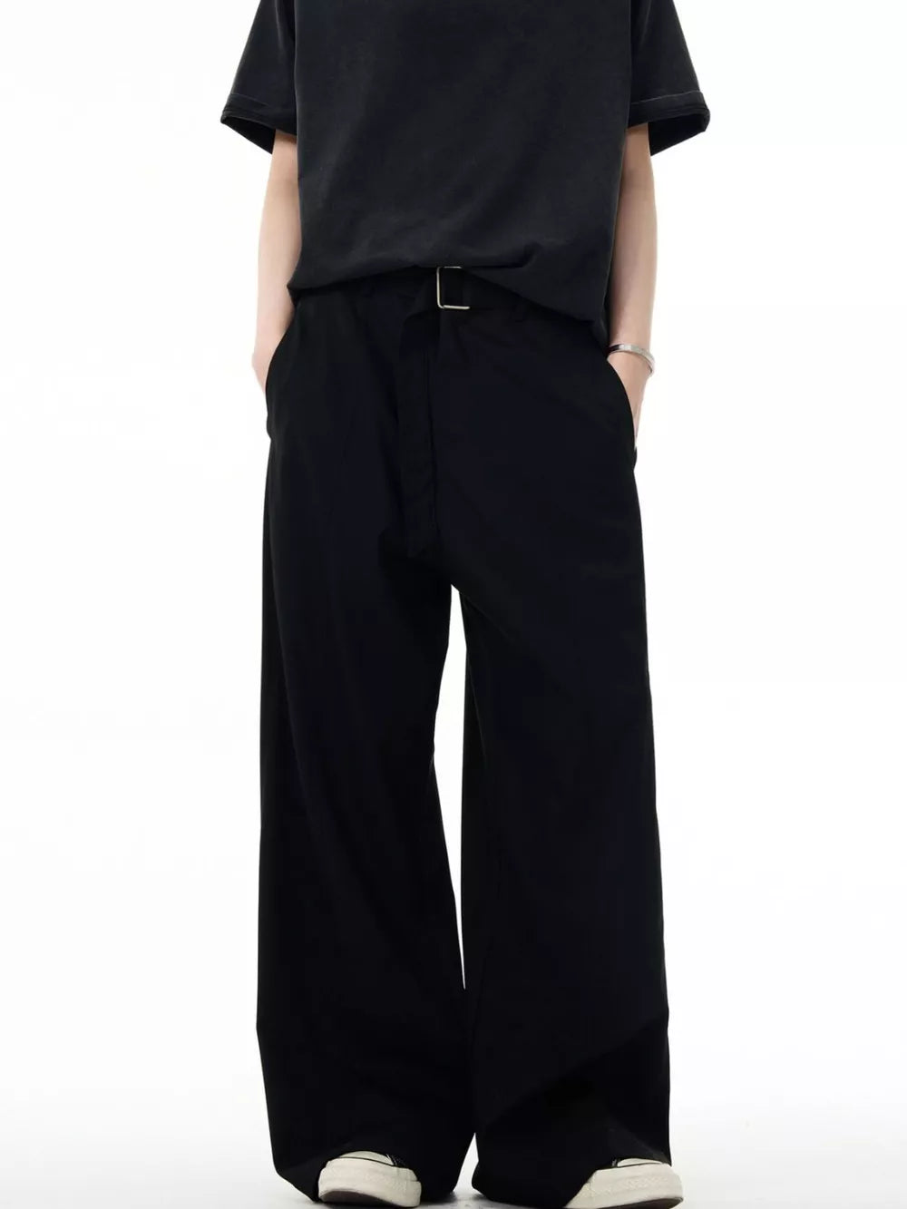 Men's black wide-leg sweatpants with a silver buckle detail and pockets.