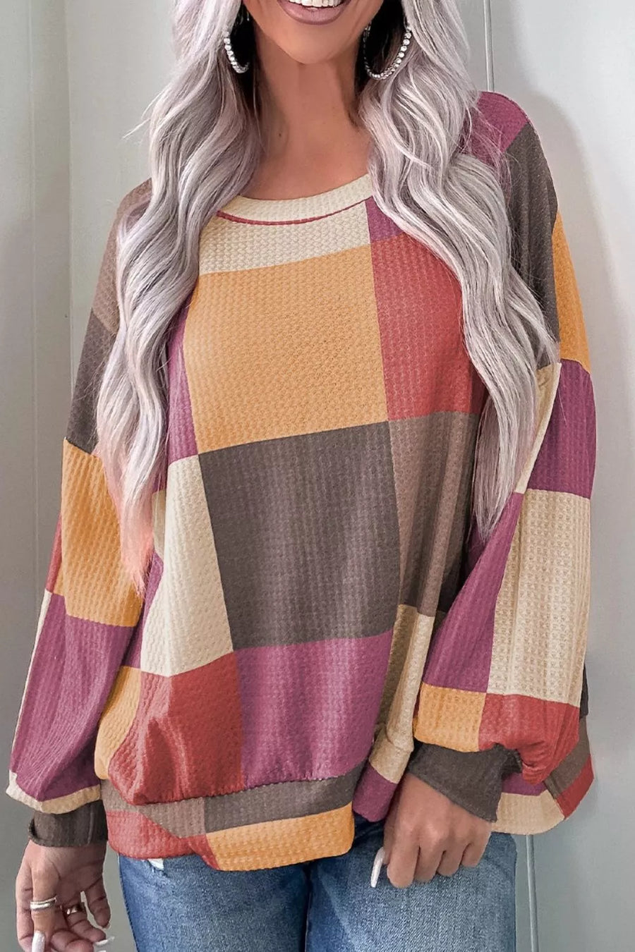 Multicolor patchwork waffle knit top with round neck and long sleeves.