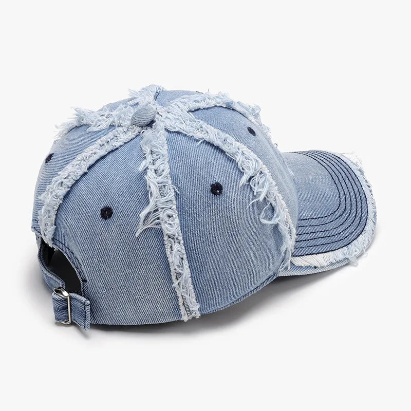 Light wash denim baseball cap with distressed frayed details and adjustable strap.
