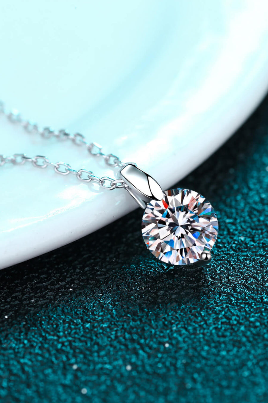 Silver moissanite pendant with a round-cut solitaire stone on a delicate chain.