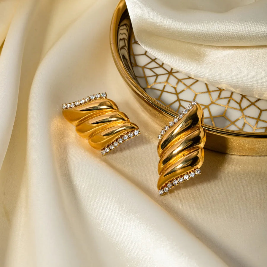 Gold sculptural wave crystal stud earrings with 18K gold plating.