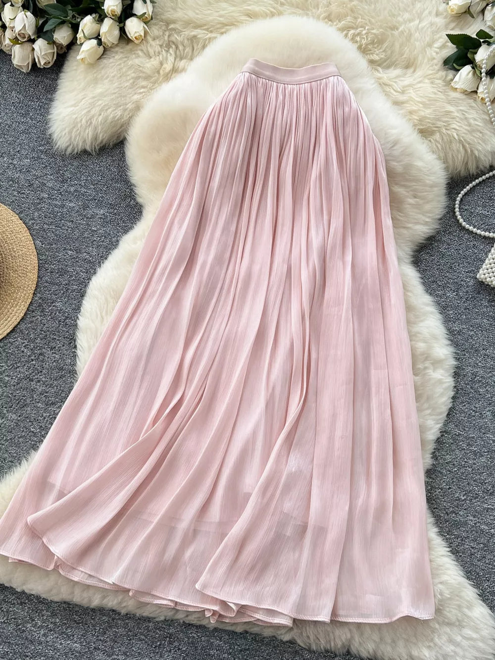 Pink pleated maxi skirt with flowing fabric and a comfortable waistband.